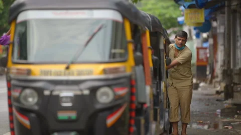 A rickshaw driver pushes his auto early morning during pandemic, Mumbai India Stock Footage 163035988