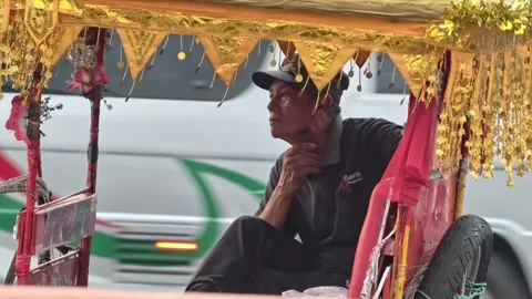 Rickshaw driver resting inside a pedicab in Sragen, Indonesia - August 04, 2026 動画素材 341422145
