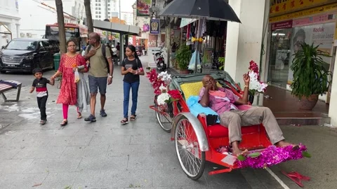 Rickshaw driver rests waiting for tourists in Georgetown, Penang, Malaysia 4K Stock Footage 260108855