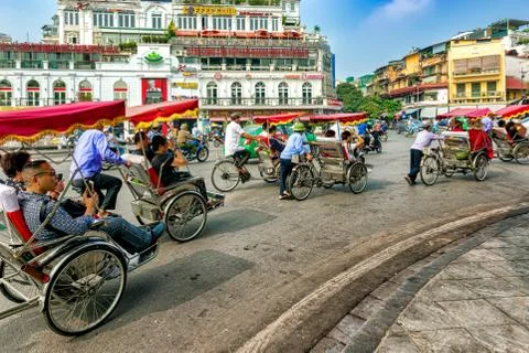 Rickshaw driving around square in old quarters in Hanoi, Vietnam. Stock Photos