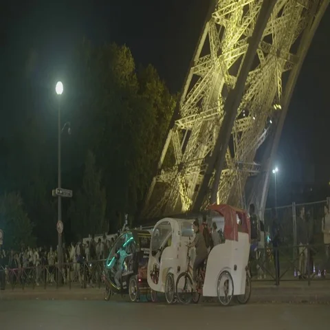 Rickshaw under The Eiffel Tower (Tour Eiffel) at Night / Paris, France - 4K Stock Footage 69728611
