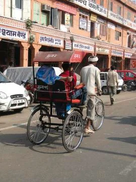 Rickshaws and their passengers weave their way through traffic Stock Photos