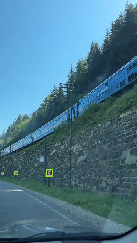 Ride car by mountain road train going next to road Stock Footage 255369880
