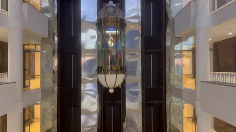 A ride in a modern glass elevator as the camera pans smoothly capturing Stock Footage 327543588