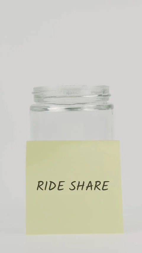 Ride share text or word on yellow sticky note attached to glass jar Stock Footage 311781896