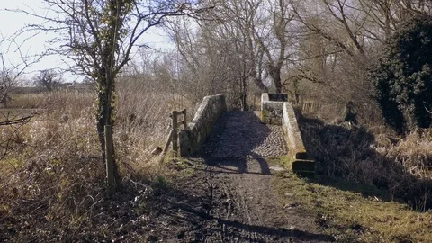 Ride through old stone sandstone bridge. Wet ground with mud and puddles. Stock Footage 87271710