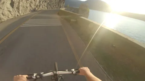 Ride your bike along the bike road on the lake with sunset Stock Footage