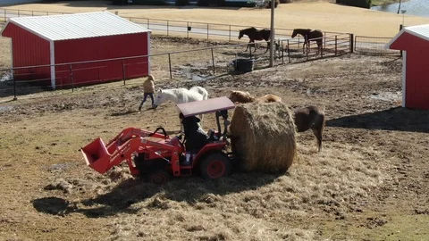 Rider and Red Barn as a Tractor Moves Hay on a Horse Farm Vidéo 121109187