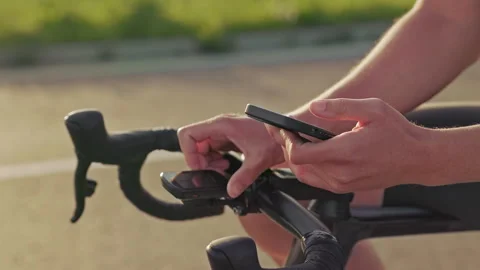 Rider comparing data from mobile app with cycle computer Stock Footage 247306592