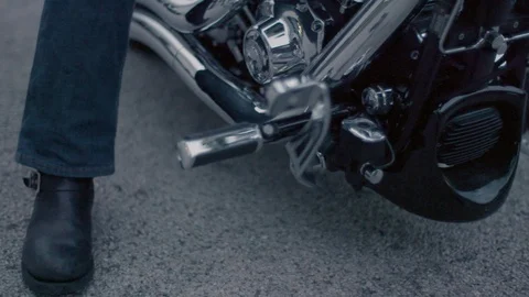 Rider getting ready to drive Harley-Davidson motorbike in slow motion Stock Footage 89979134