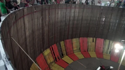 Rider performs on a vertical circular track using a motorbike during festival. Vídeo Stock 262546658