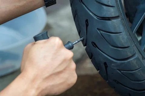 Rider use a tire plug kit and trying to fix a hole in tire's sidewall ,Repa.. Stock Photos