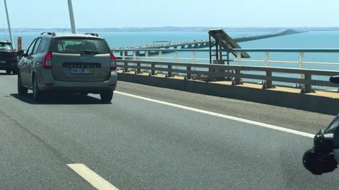 Riders and drivers make their way across the Vasco da Gama Bridge, Lisbon Video stock 284300390