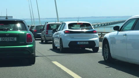 Riders and drivers make their way across the Vasco da Gama Bridge Stock Footage 284354615