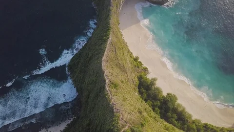 Ridge of green mountains surrounded with blue ocean waves top down view Video stock 101670047
