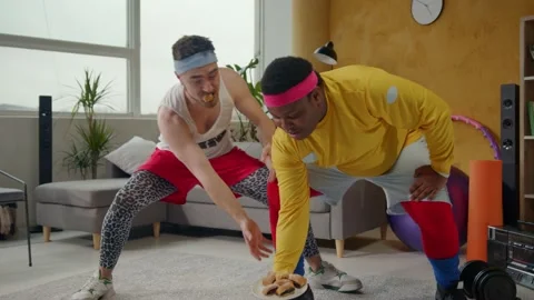 Ridiculous amazing multi-ethnic weak men lifting plate with cookies. Weird Stock Footage 133074323