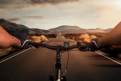 Riding a bicycle on an empty highway through the volcanic landscape Stock Photos