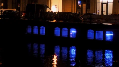Riding a bicycle over a luminous/lighted bridge, reflection of light in water Stock Footage 125818443