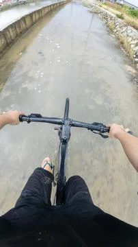 Riding Bicycle Through Flooded Path 스톡 사진