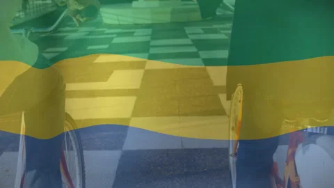 Riding bicycles over checkered pavement, two people with translucent flag Stock Footage 303441815