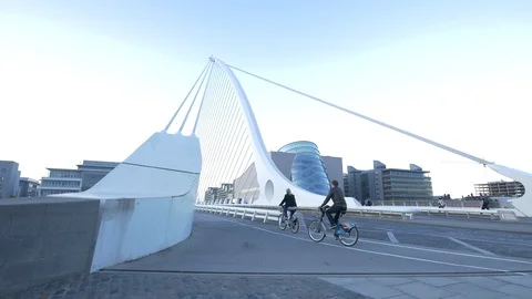 Riding bikes on a bridge in Dublin Stock Footage 86509676