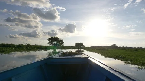 Riding a boat on a river reflection the sun and clouds Stock Footage 129406372