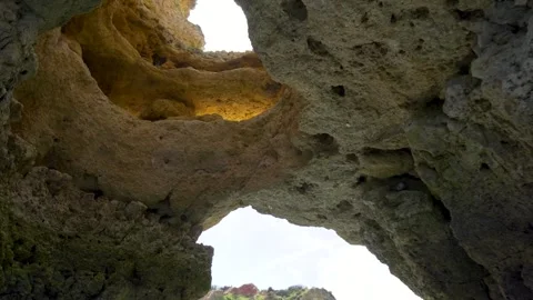 Riding a boat through a stone cave with holes in cliff formation in Portugal Stock Footage 273286137