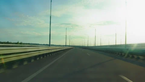 Riding on bridge flyover of road interchange ramp. View through rear windshield Stock Footage 268426039
