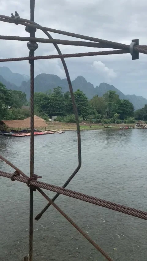 Riding on a bridge over a river in Vang Vieng Видео 343320231