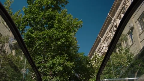 Riding an escalator outdoors with tree and building reflections Stock Footage 338244233