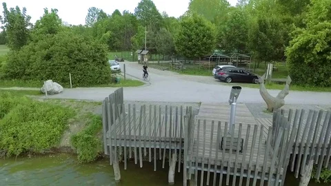 Riding his bike towards the pier and stopping there Stock Footage