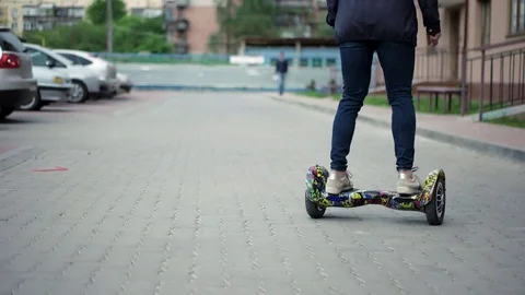 Riding Hoverboard or Electric Self Balancing Gyro Scooter Board on the Side Walk Stock Footage 75947012