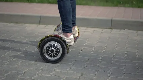 Riding Hoverboard or Electric Self Balancing Gyro Scooter Board on the Side Walk Stockbeeldmateriaal 75947111