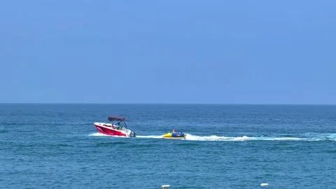 Riding inflatable donut behind a fast boat, riding an inflatable ring on the sea Stock Footage 312760247