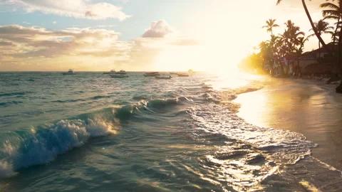Riding low over turquoise waves in as they wash over a beach in Punta Cana Stock Footage 316245964