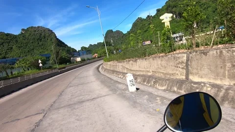 Riding a motorcycle on a highway between limestone mountains. Vietnam Stock-Footage 158386647