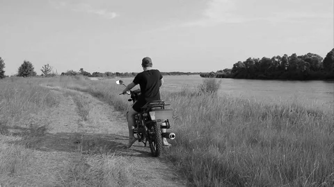 Riding a motorcycle parallel to the river in search of a new route Video stock 113217007