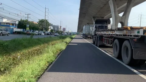 Riding motorcycle with speed point of view towards street trucks on road Stock Footage 248818375