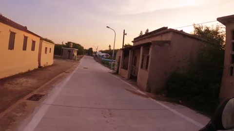 Riding moving forward view in a peaceful countryside town village with antique o Stock Footage 240483224