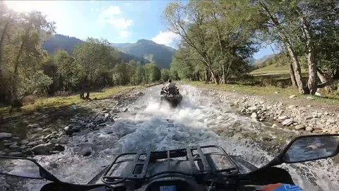 Riding a quad on a mountain river, first-person Video stock 98084496