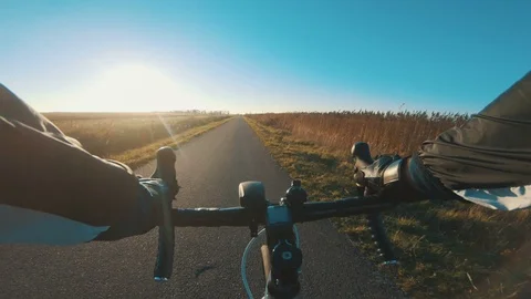 Riding racing bicycle as the sun sets on a clear blue sky in autumn Stock Footage 98770786