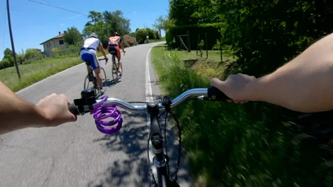 Riding on a rural road while being overtaken by a professional cyclists Stock Footage 150392032