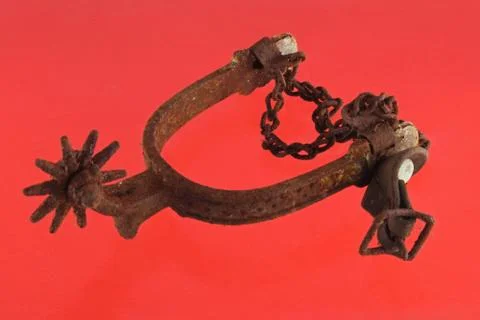 Riding spur on red background. Stock Photos