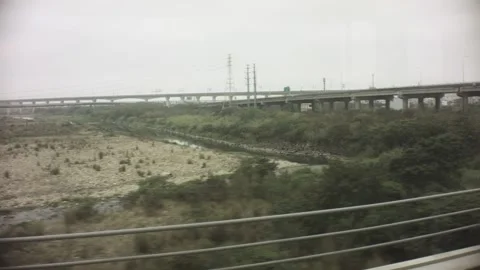 Riding on train view of a look out to the dry riverbed field with bush passing u Stock Footage 237251840