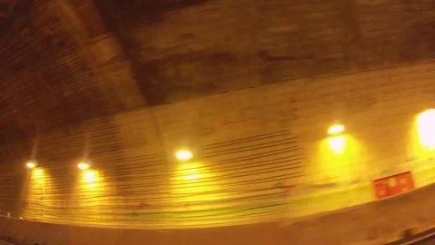 Riding in vehicle looking out the window entering to dark tunnel passageway bene Stock Footage 266504561