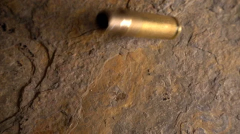 Rifle bullet casing falls to ground, 250fps Stock Footage 61815984