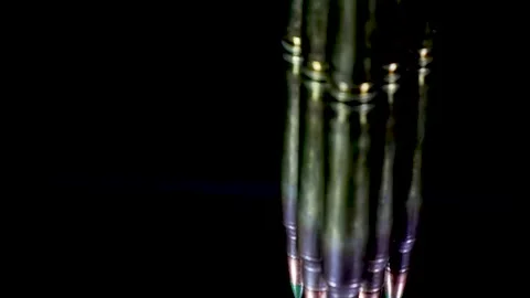 Rifle bullets rotating and casting their reflection on the glass table Stock Footage 263063741