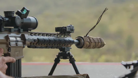 A rifle is fired by a sniper, with the string from the suppressor swaying in 库存影片 334351209