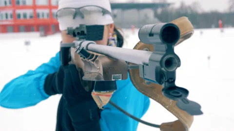 A rifle with its muzzle in the hands of a female biathlete Stock Footage 99621481