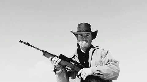 Rifleman in Black Hat B&W Shoots Gun into lens Stock Footage
